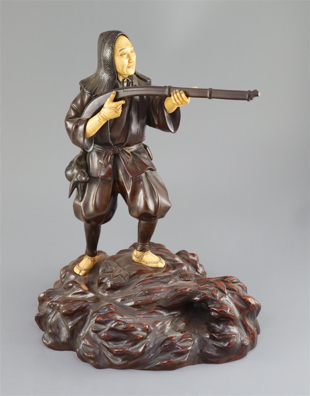 A good Japanese bronze and ivory okimono of a huntsman, Meiji period, 34cm high